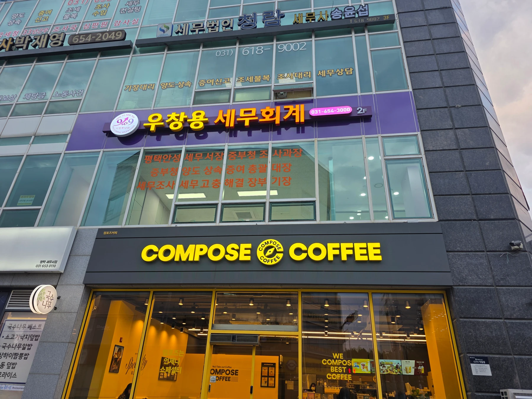 1층 컴포즈커피와 2층 우창용 세무회계 간판이 함께 보이는 세비온빌딩 외관