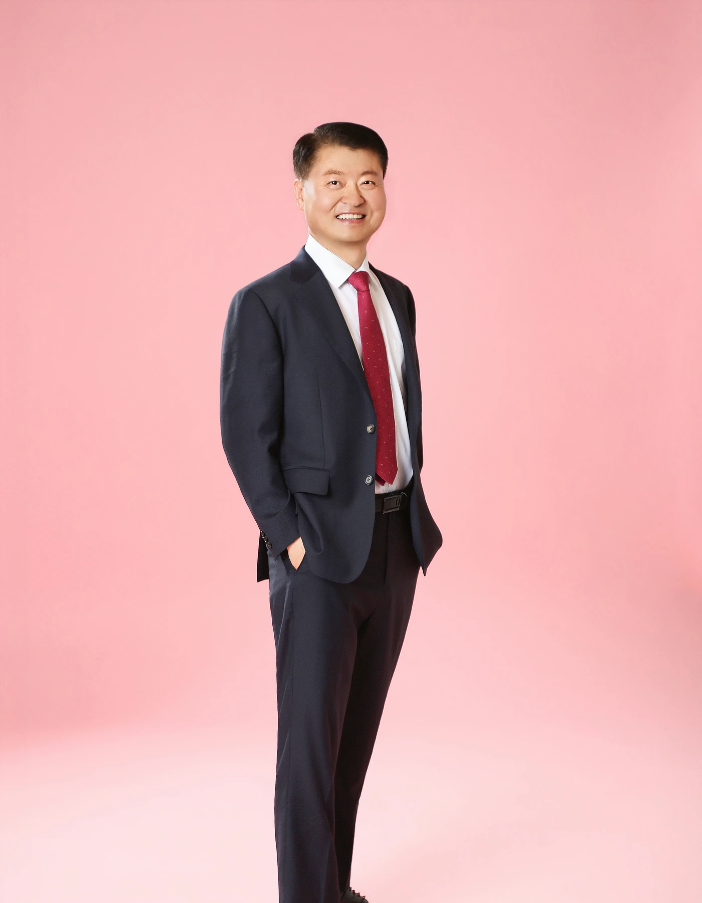 핑크 배경 앞에 선 우창용 세무회계 대표 세무사 우창용